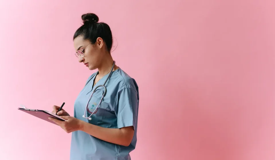 Healthcare worker writing on a clipboard