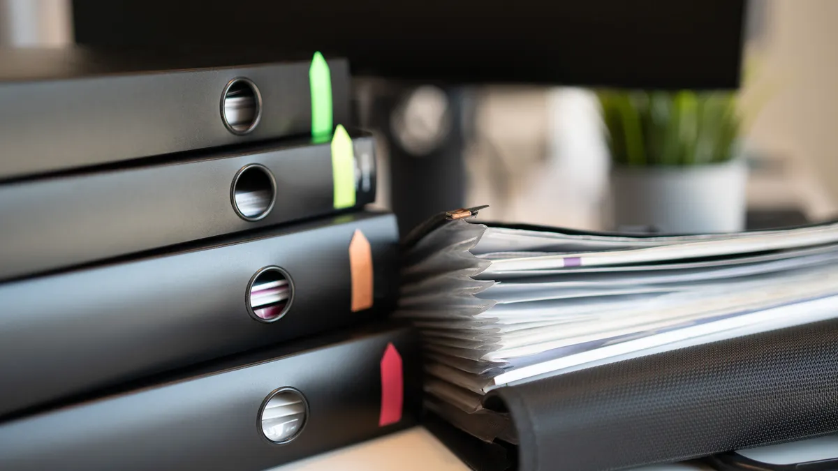 Caregiver paperwork: which legal and medical documents to keep together Stack of binders with paper documents