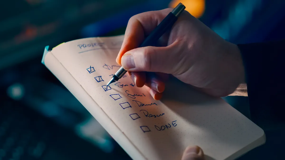 Hand checking items on a notebook list