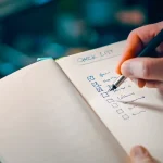 Hand ticking a checklist in a notebook