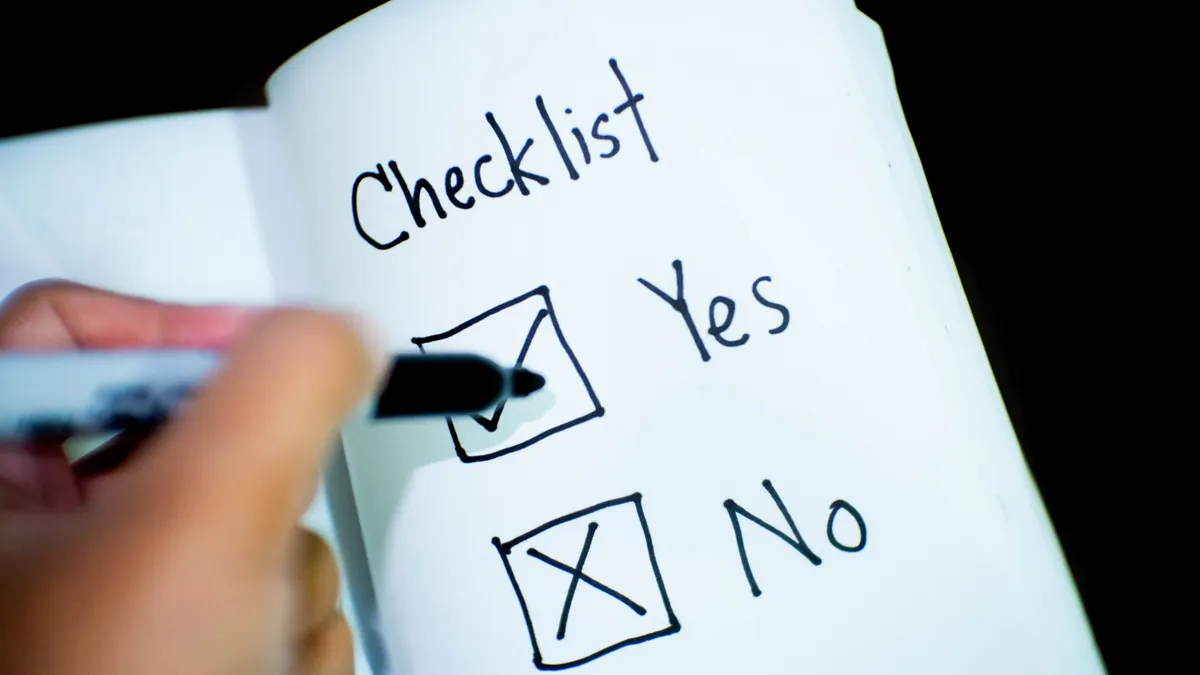 Hand marking yes and no boxes in a checklist