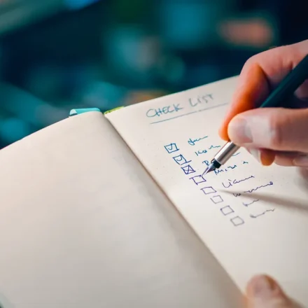 Hand ticking a checklist in a notebook
